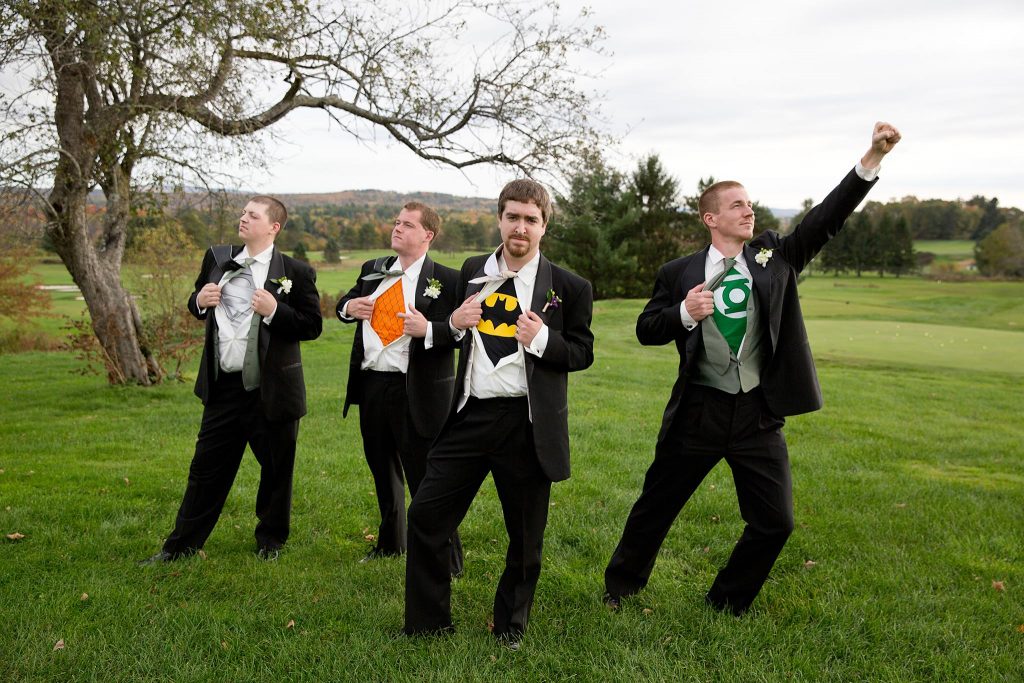 photo of four extremely handsome men (groom and three groomsmen) showing off their super hero teeshirts under their tuxes