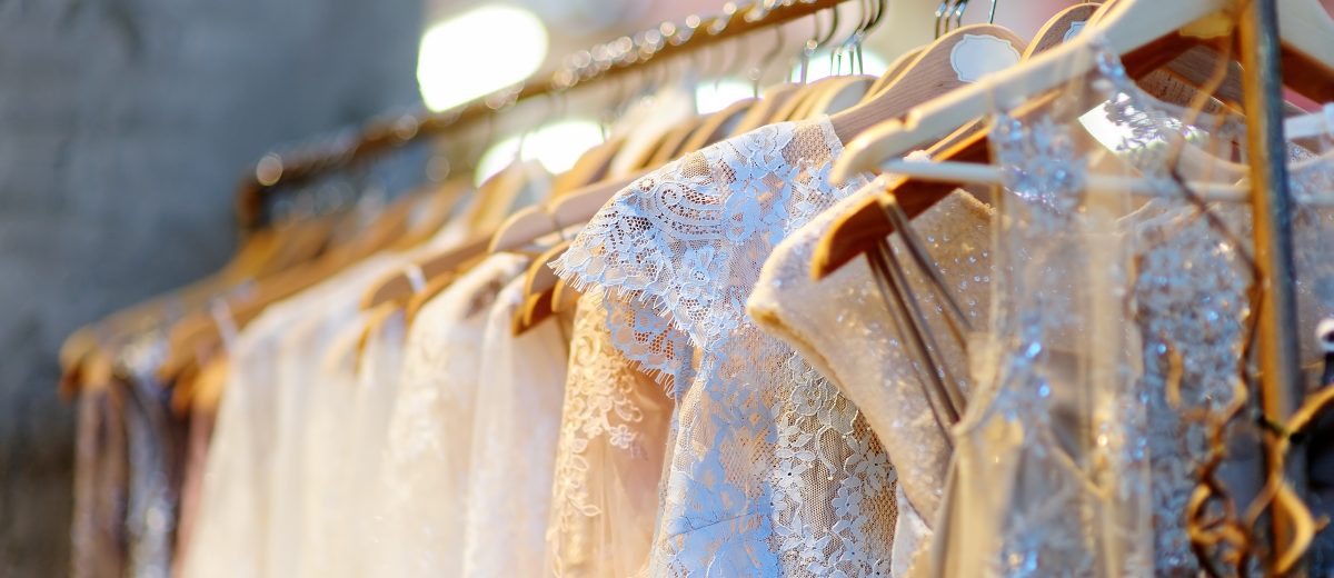 A few beautiful wedding dresses on a hanger.