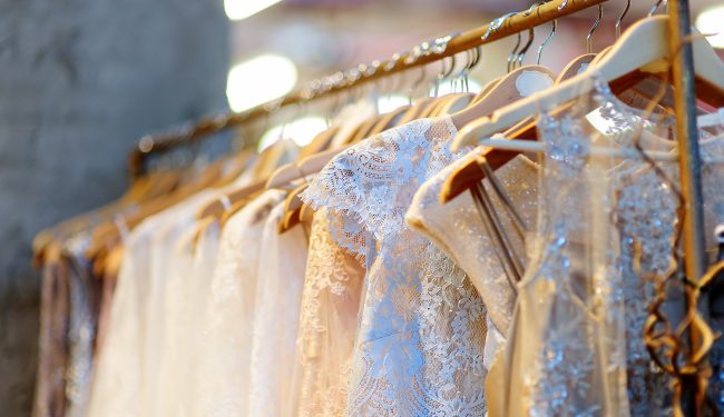 A few beautiful wedding dresses on a hanger.