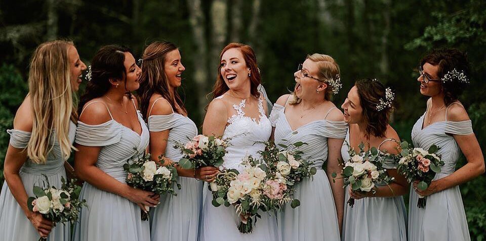 photo of bride and bridesmaids laughing in a forest
