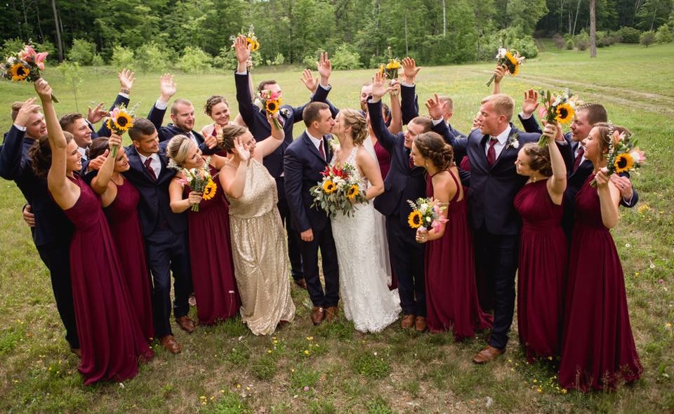 photo of bride and groom kissing while bridal party celebrates