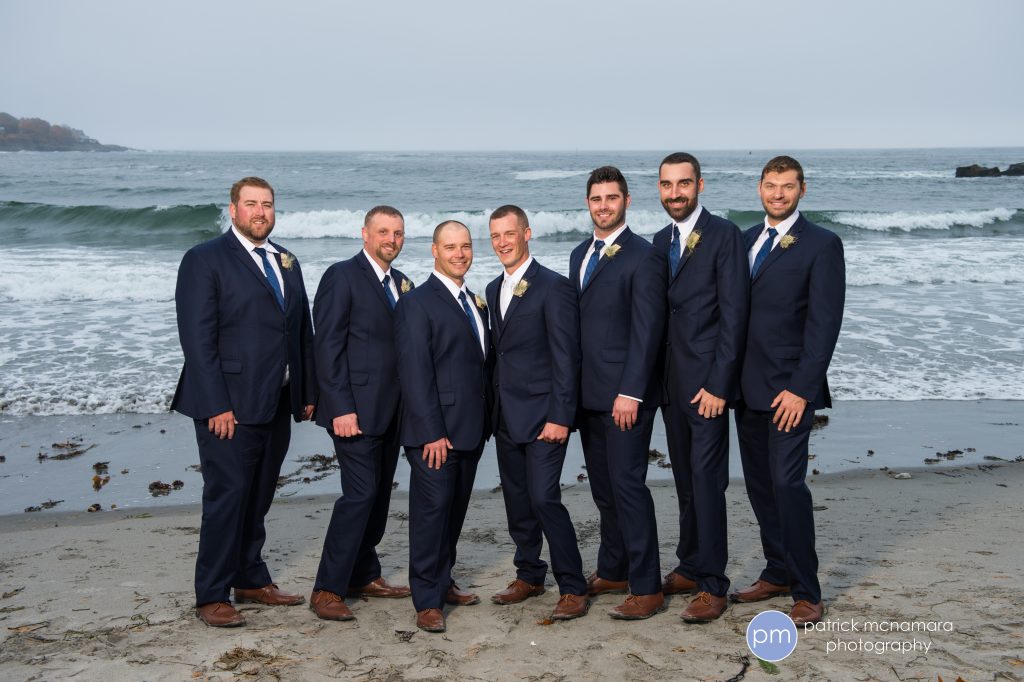 photo of groom and groomsmen in front of crashing waves