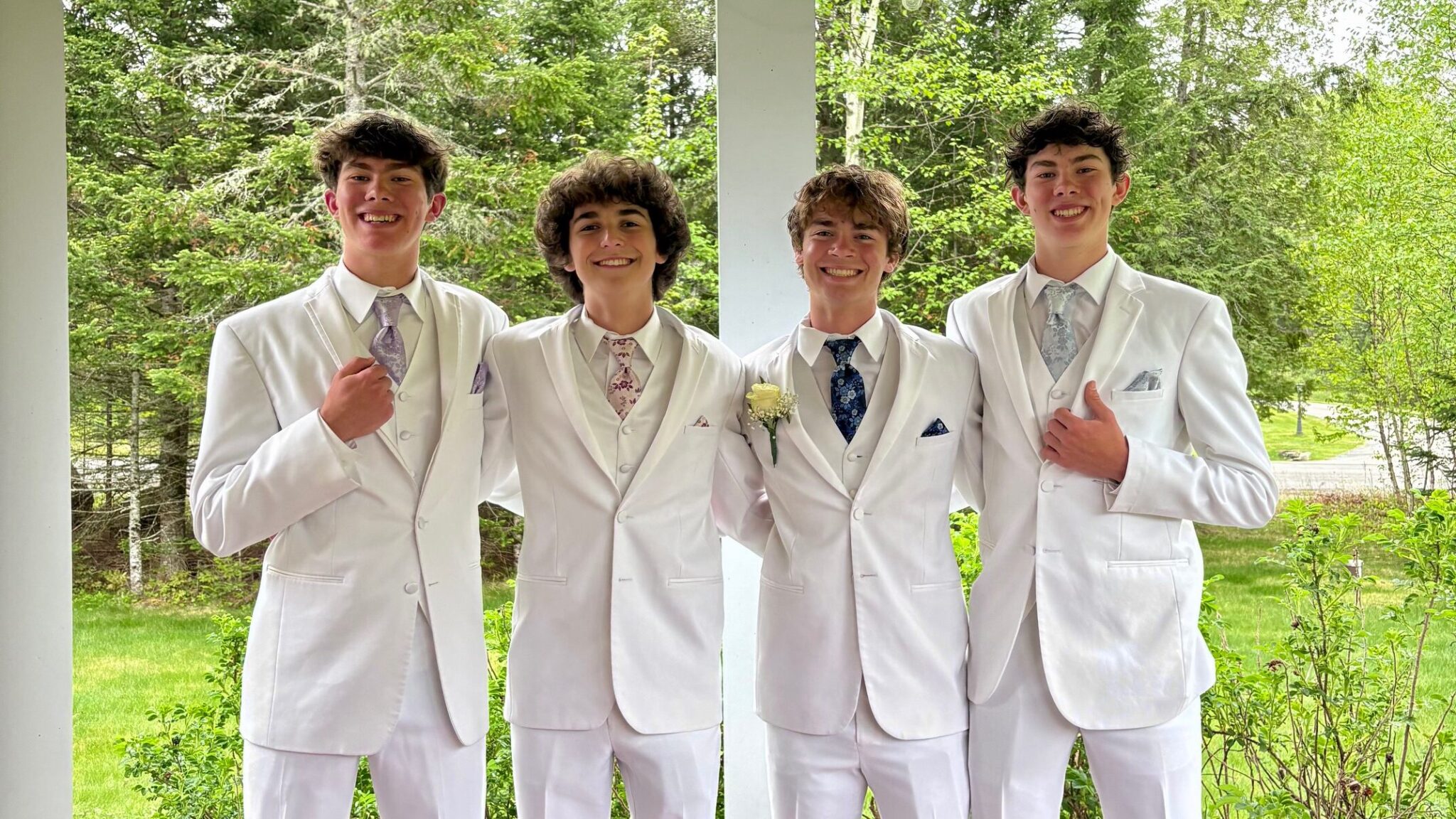 4 boys wearing all white tuxedos